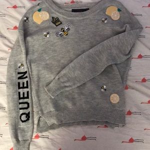 Woman’s “queen bee” sweater